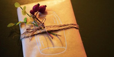 Dárek zabalený v hnědém balícím papíře s šípkovou ozdobou