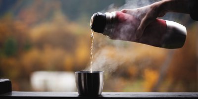 Žena nalévá čaj do vršku termosky