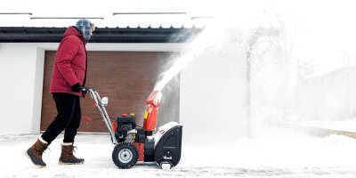 Muž používá frézu před domem