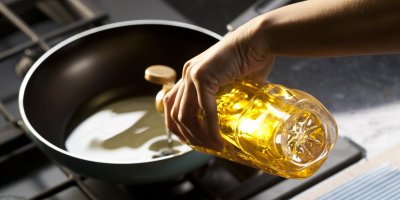 Člověk nalévá olej na pánev