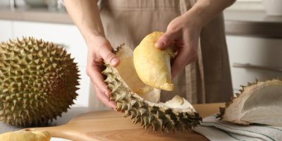 Žena loupe durian v kuchyni
