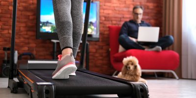 Pes a manžel na gauči sledují ženu na běžícím pásu