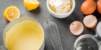 Holandská omáčka v hrnci, metlička, citron, máslo, vaječné skořápky