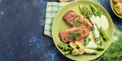 Opečený losos se zeleným chřestem, který je přelitý holandskou omáčkou