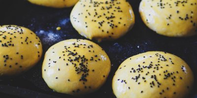 Nakynuté housky posypané lněným semínkem a potřené bílkem na plechu