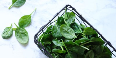 Listy špenátu v černém košíku