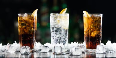 Tři sklenice s kolou a perlivou vodou, ledem a plátky citronu