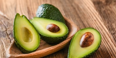 Rozpůlená avokáda na dřevěném prkénku