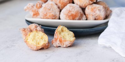 Talíř s koblížky a tři koblížky vedle něj