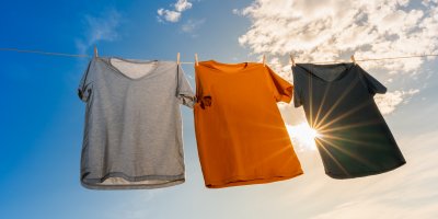 Tři trička pověšená na šňůře, slunce