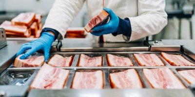 Balení kusů slaniny v závodě