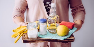 Žena drží na podnose ingredience k výrobě domácího čisticího prostředku