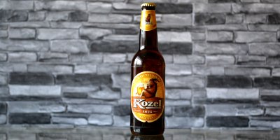 Láhev světlého piva Kozel v hnědo-žlutém provedení