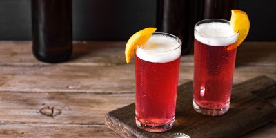 Dvě sklenice červeného radleru ozdobené měsíčky pomerančů