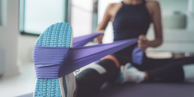 Žena se protahuje po cvičení pomocí odporové gumy