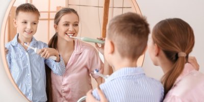 Matka se synem si čistí zuby před zrcadlem