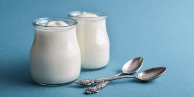 Dvě skleničky s řeckým jogurtem, dvě lžičky