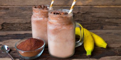 Smoothie ve sklenici a kolem namletá káva a banány