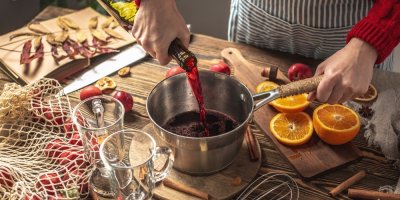 Muže leje červené víno do kastrůlku