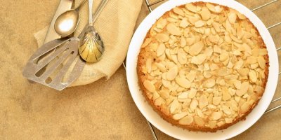 Mandlový dort na bílém talíři, okolo nádobí