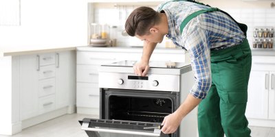 Muž opravuje pokaženou troubu.