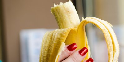 Ženská ruka drží rozjedený banán