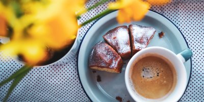 Nakrájená bábovka na talířku s hrnkem kávy