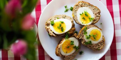 Talíř s rozkrojenými skotskými vejci posypanými nasekanou petrželkou