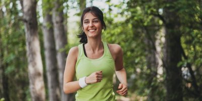 Mladá žena se usmívá při běhu.