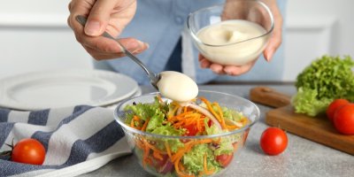 Žena ochucuje salát domácí majonézou