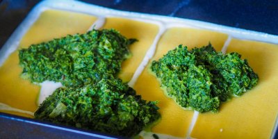 Na plechu je bešamel, na něm pláty lasagní, na nich špenátová náplň