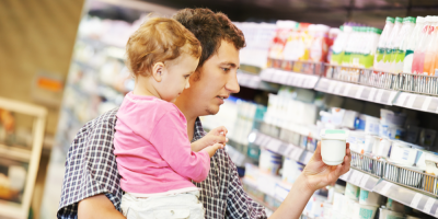 Otec a malá dívka vybírají mléčné výrobky v obchodě 