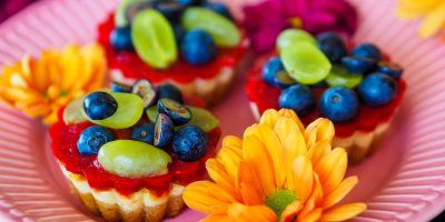 Mini dezerty ozdobené borůvkami a plody hroznového vína, květinová dekorace