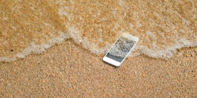 Telefon ležící na okraji moře