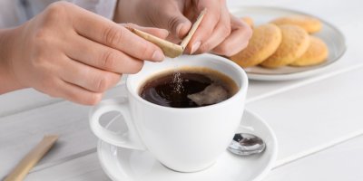 Sypání cukru do kávy