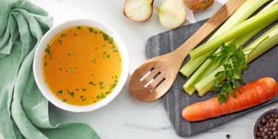 Miska kuřecího vývaru s použitou zeleninou (mrkev a řapíkatý celer), kuličky pepře