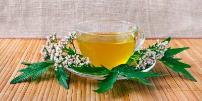 Šálek čaje z kozlíku lékařského s jeho květy a listy