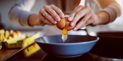 Žena rozklepává vajíčko do misky