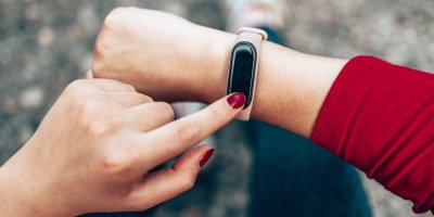 Žena nastavuje chytrý náramek na svém zápěstí