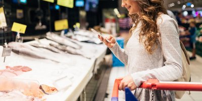 Žena v supermarketu stojící u pultu s rybami