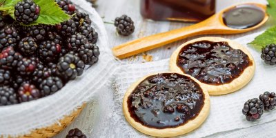 Miska s ostružinami a ostružinová marmeláda namazaná na lívance