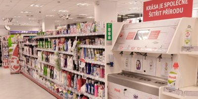 Plnicí stanice drogerie Rossmann stojící vedle regálů s rozličnými přípravky