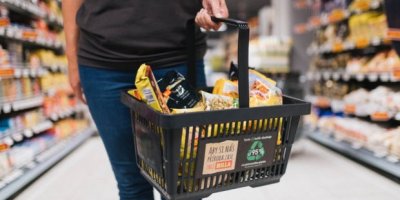 Člověk s plným nákupním košíkem v obchodě Billa