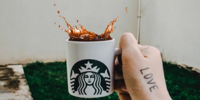 Ruka držící hrnek Starbucks s kávou