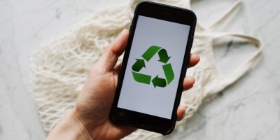Ruka drží telefon s obrázkem recyklace
