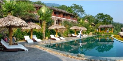 Exotické letovisko s bazénem, lehátky a palmovými přístřešky