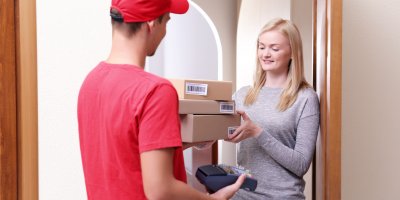 Kurýr doručující ženě balíčky