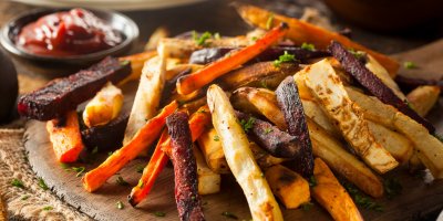 Hromada různých druhů zeleninových hranolek na dřevěném podnosu