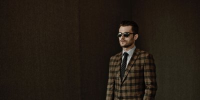 Leoš Mareš v hnědém obleku a slunečních brýlích