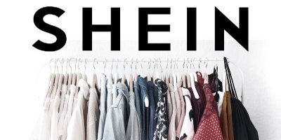 Stojan na oblečení s ramínky a na nich pověšeným oblečením